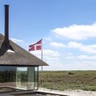 Skønt sommrhus beliggende ved havet. Se her udefra med KRONE vinduer, glashjørner og skydedøre.